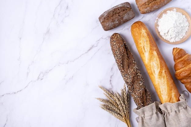 Boulangerie divers types de pain Petits pains baguette croissant et farine vue de dessus mise à plat