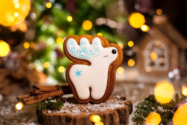 Boulangerie traditionnelle de vacances. Cerf de Noël blanc en pain d'épice dans une décoration chaleureuse avec des guirlandes