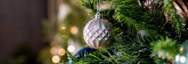 Boule argentée et rose accrochée à un arbre de neige décoré Fond de vacances de Noël Boule de jouet de Noël Arbre du nouvel an décoré d'une guirlande