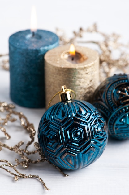Boule bleue, bougies arôme doré et jouets de Noël sur bois rustique