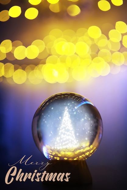 Boule de cristal au sol avec bokeh, lumières derrière. Boule de verre avec lumière bokeh colorée, concept de célébration du nouvel an.