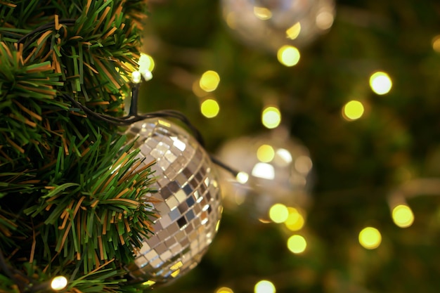 Boule de cristal décorée sur le pin le jour de Noël avec arrière-plan flou et bokeh