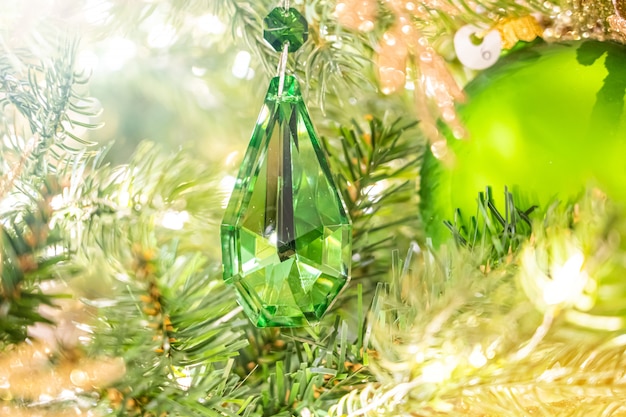 Boule de cristal de Noël vert brillant suspendu à des branches de pin