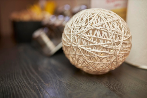 une boule décorative de fil blanc et de colle se trouve sur la table