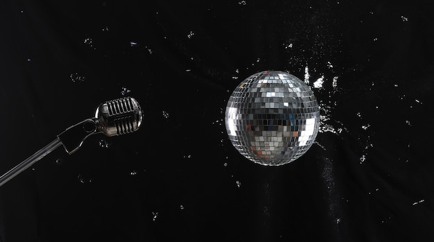 boule disco et microphone sur fond noir