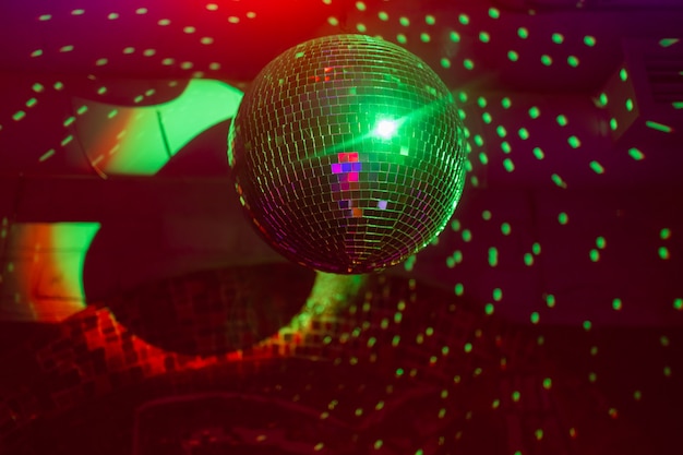 Boule à facettes disco reflétant les lumières violettes.