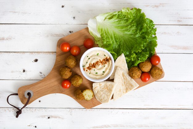 Boule de falafel avec houmous sur planche à découper vue de dessus