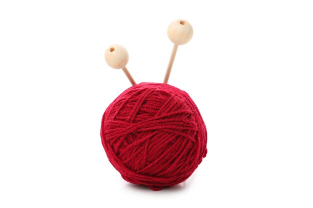 Boule de fil rouge avec des aiguilles à tricoter, isolée sur fond blanc.
