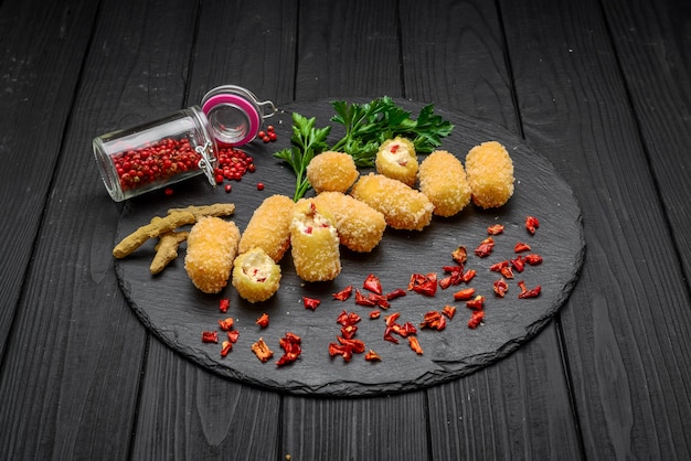 Boule de fromage frit, pépites de fromage sur une plaque en bois