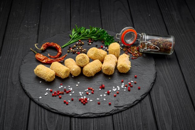 Boule de fromage frit, pépites de fromage sur une plaque en bois