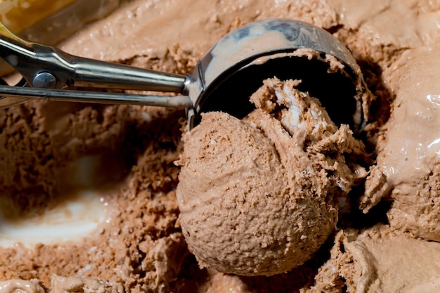 Une boule de glace au chocolat avec une cuillère qui dit "glace au chocolat" dessus