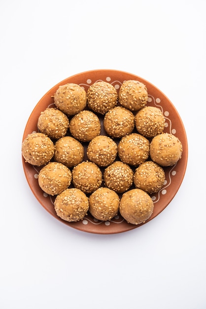 Boule de jaggery aux graines de sésame ou til ke laddo et tilgul ou til gul laddu servi dans un bol pour le festival Makar Sankranti en Inde