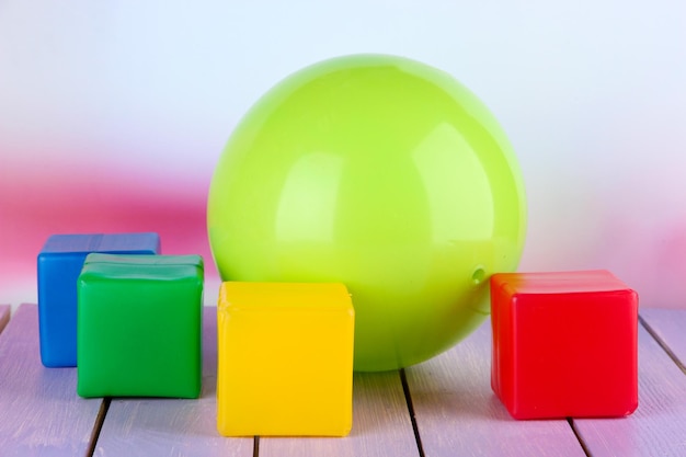 Boule lumineuse et cubes colorés sur table sur fond clair