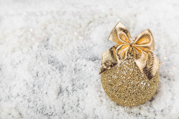 Boule de Noël avec arc sur la neige