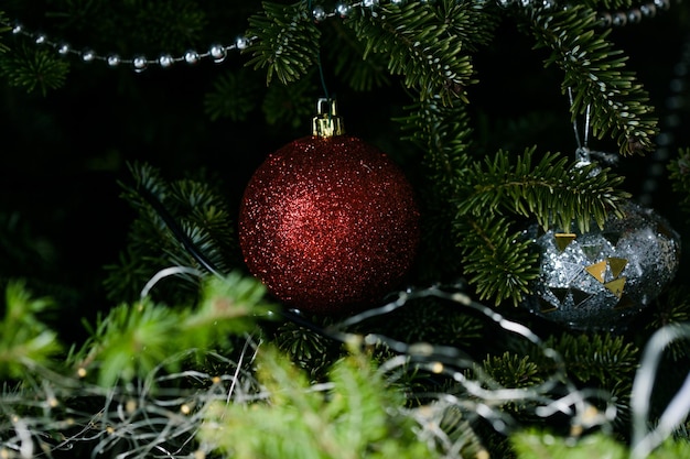 Boule de Noël argentée avec un flocon de neige sur un gros plan d'arbre de Noël