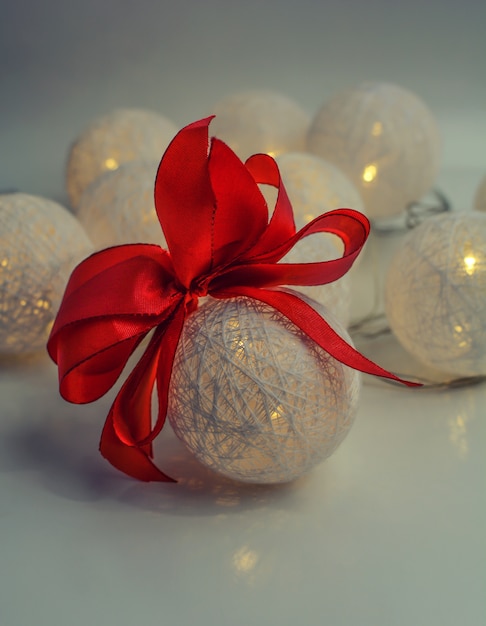 Boule de Noël blanche avec un arc rouge