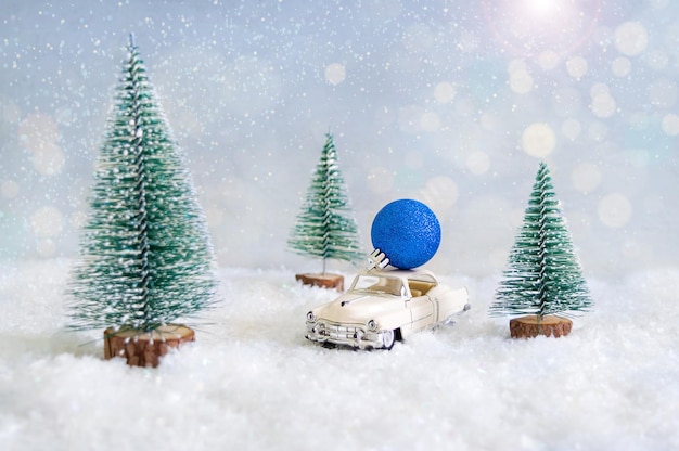 Boule de Noël bleu vif sur la petite voiture avec arrière-plan flou et neige