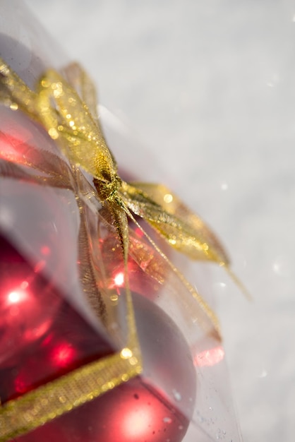 boule de noël en boîte sur la neige fraîche à la belle journée d'hiver ensoleillée avec ombre portée