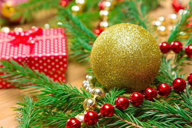 Boule de Noël dorée et perles de couleur avec branches d'épinette et boîte cadeau Faible profondeur de champ