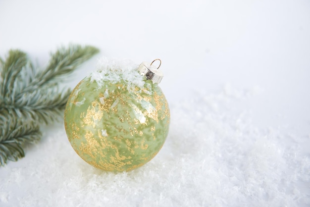 Boule de Noël festive sur fond blanc avec des branches de neige et de sapin