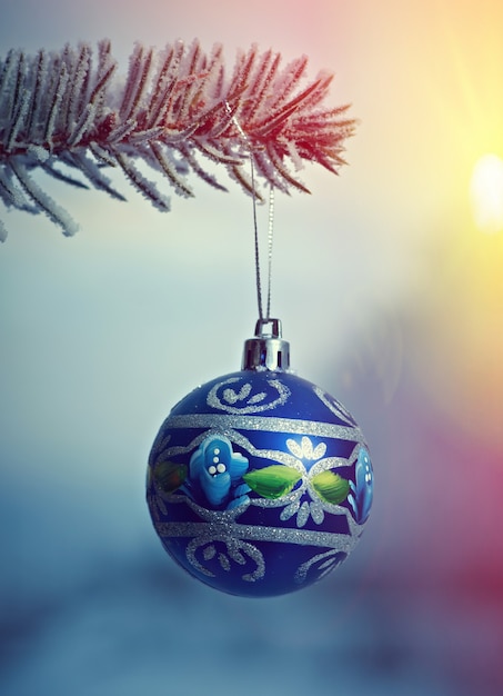 Boule de Noël lumineuse d'une branche d'arbre de Noël couverte de neige