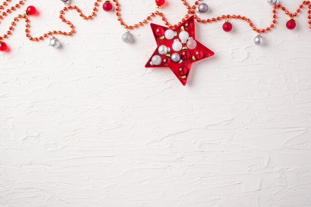 Boule de Noël et ornement de décoration de guirlandes et d'étoiles sur fond de table en béton blanc