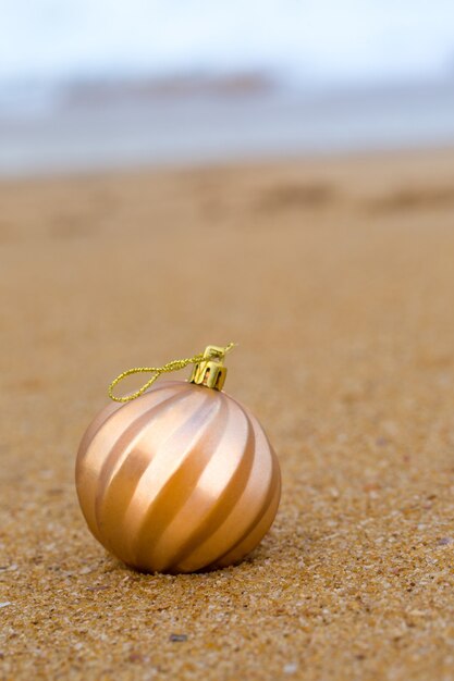 Boule de Noël sur une plage de sable