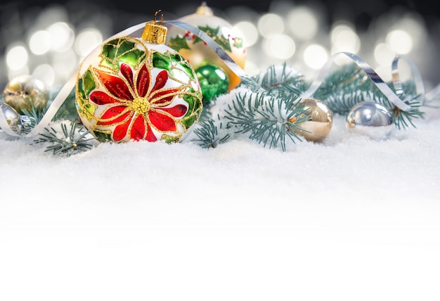 Boule de Noël avec poinsettias, branches de sapin de Noël sur neige