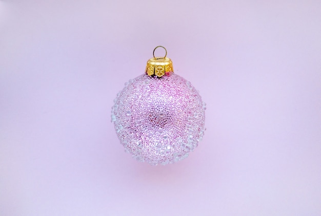 Photo boule de noël rose avec quelques bosses sur fond rose lieu de conception de noël minimal pour le texte