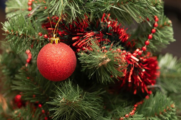 Boule de Noël rouge sur l'arbre avec des perles