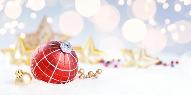 Boule de Noël rouge avec décoration sur neige.