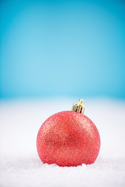 Boule de Noël rouge sur la neige