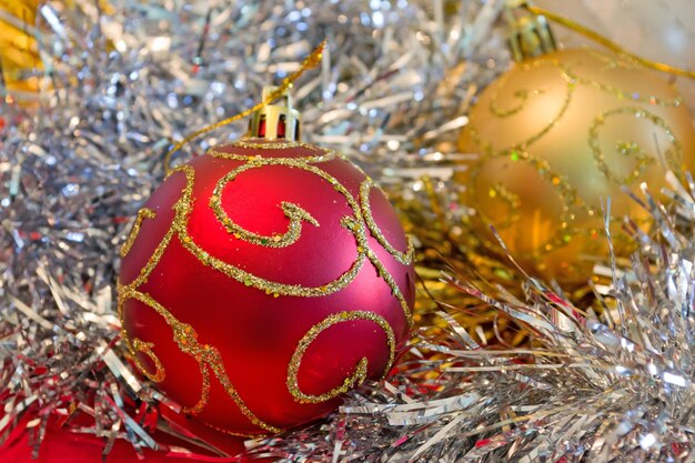 Boule de Noël rouge et or entourée d'une décoration argentée