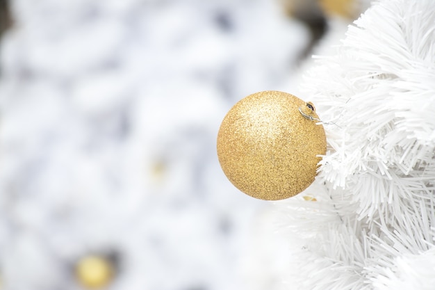 Boule d&#39;or sur une branche blanche de fond d&#39;arbre de Noël