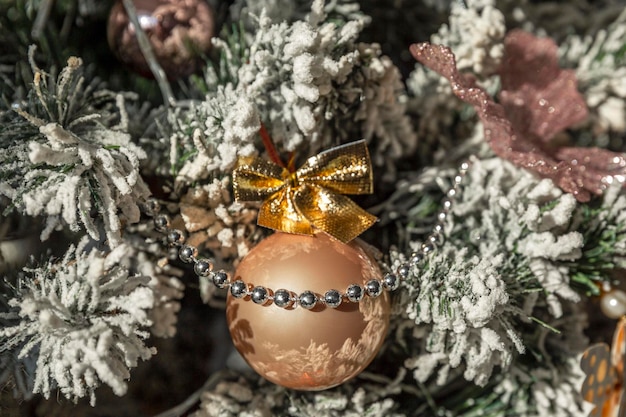 Boule d'or jouet du Nouvel An sur un arbre de Noël décoré Traditions et vacances Gros plan