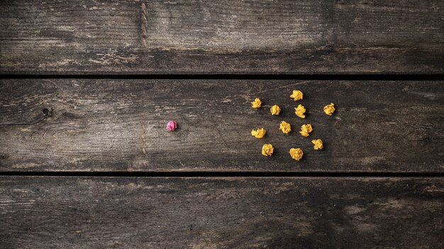 Boule de papier froissé rose se détachant de la foule des autres, jaunes.