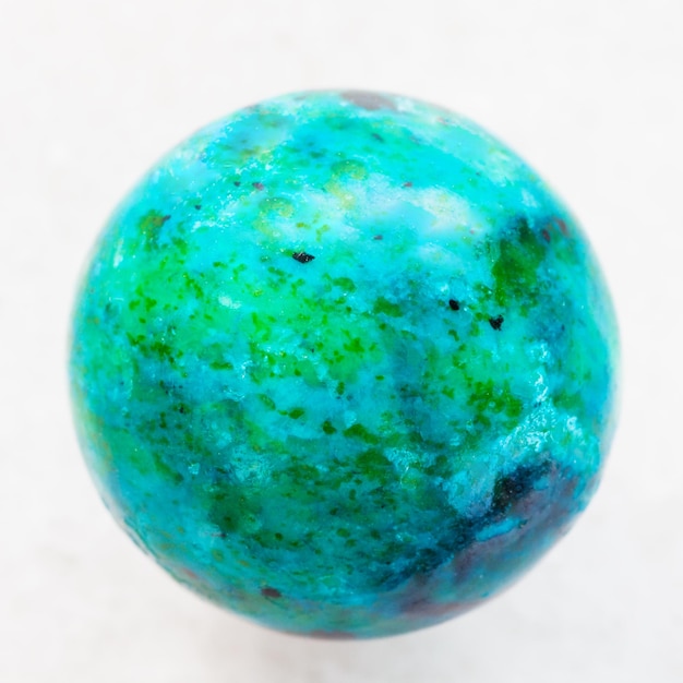 Boule de pierre gemme de chrysocolle sur le marbre blanc