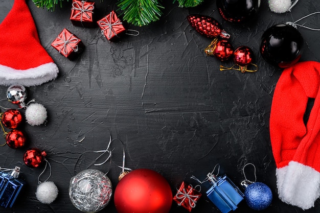 Boule pour l'ensemble d'arbres de Noël, cadre, vue de dessus à plat, sur fond de table en pierre noire noire, avec espace de copie pour le texte