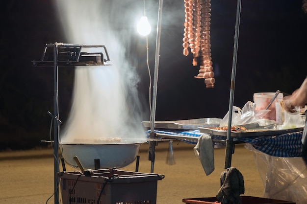 Boule de riz à la saucisse pendre et fumée de poêle et vente dans la rue