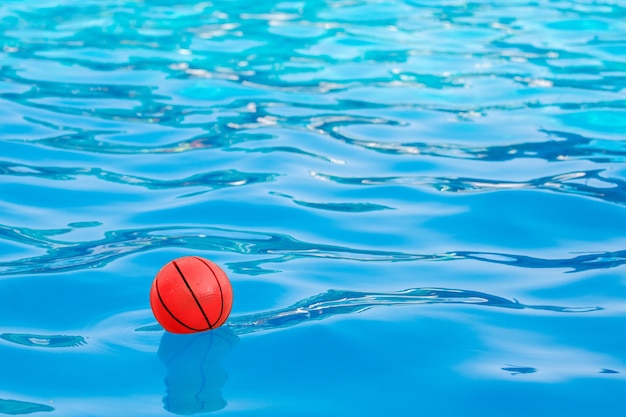 Boule rouge sur l'eau bleue de la piscine_