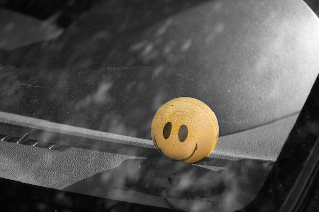 Photo boule de sourire jaune en voiture. vue arrière grise.