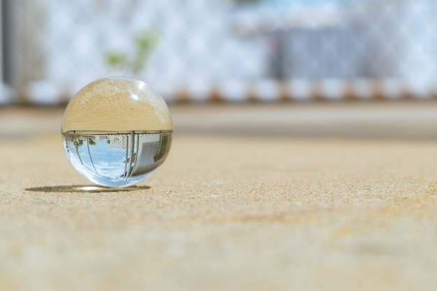 Une boule de verre est posée sur le sol au soleil.