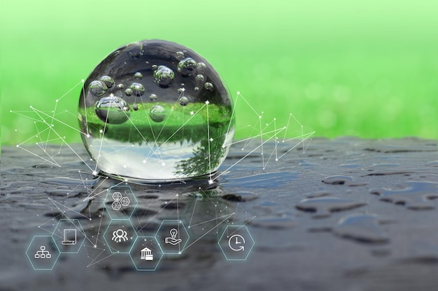 Photo une boule de verre sur fond bleu est comme une goutte d'eau le concept d'icônes écologiques avec des symboles