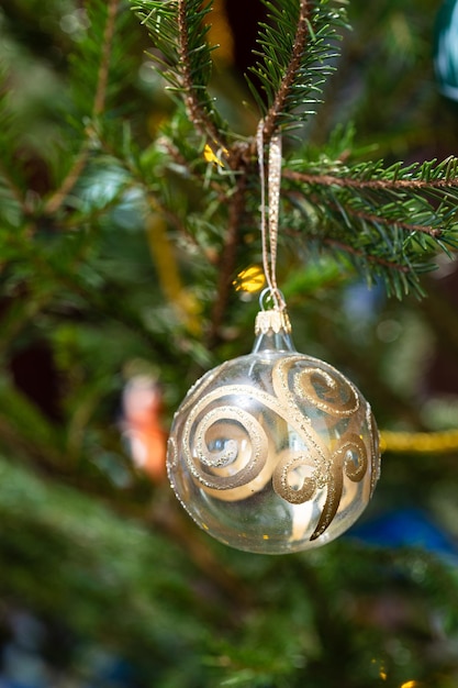 Boule de verre avec ornement doré sur l'arbre de Noël