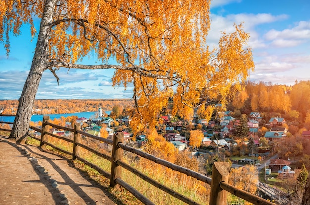 Photo bouleau jaune sur cathedral mountain à plyos et vue sur les maisons colorées en journée ensoleillée d'automne