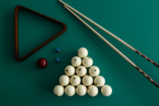 Boules de billard russes, queue, triangle, craie sur une table. Drap vert Vue de dessus