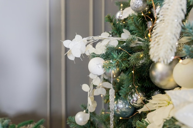 Boules blanches argentées sur l'arbre de Noël en givre artificiel Nouvel An et attribut de Noël pour les cartes de voeux ou les félicitations Idée d'atmosphère de conte de fées de fond décorant la maison pour les vacances