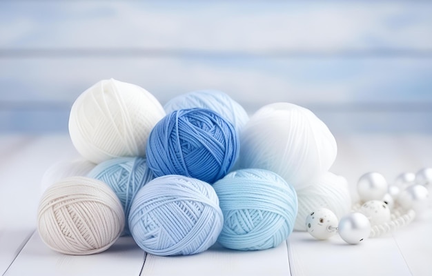 Boules colorées de fil et aiguilles à tricoter en métal sur un fond blanc