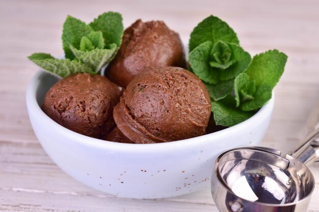 Boules de crème glacée au chocolat avec des feuilles de menthe dans un bol