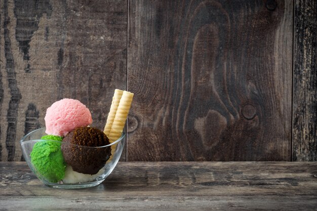 Boules de crème glacée dans un bol en cristal sur l'espace de copie de table en bois